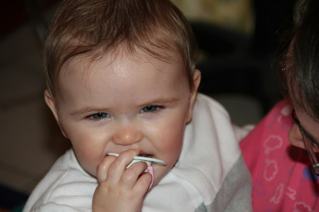 baby in white long sleeve shirt