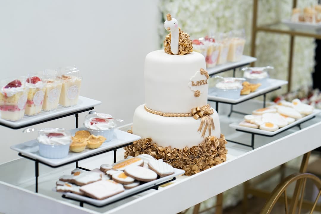 a table topped with a white cake and lots of desserts