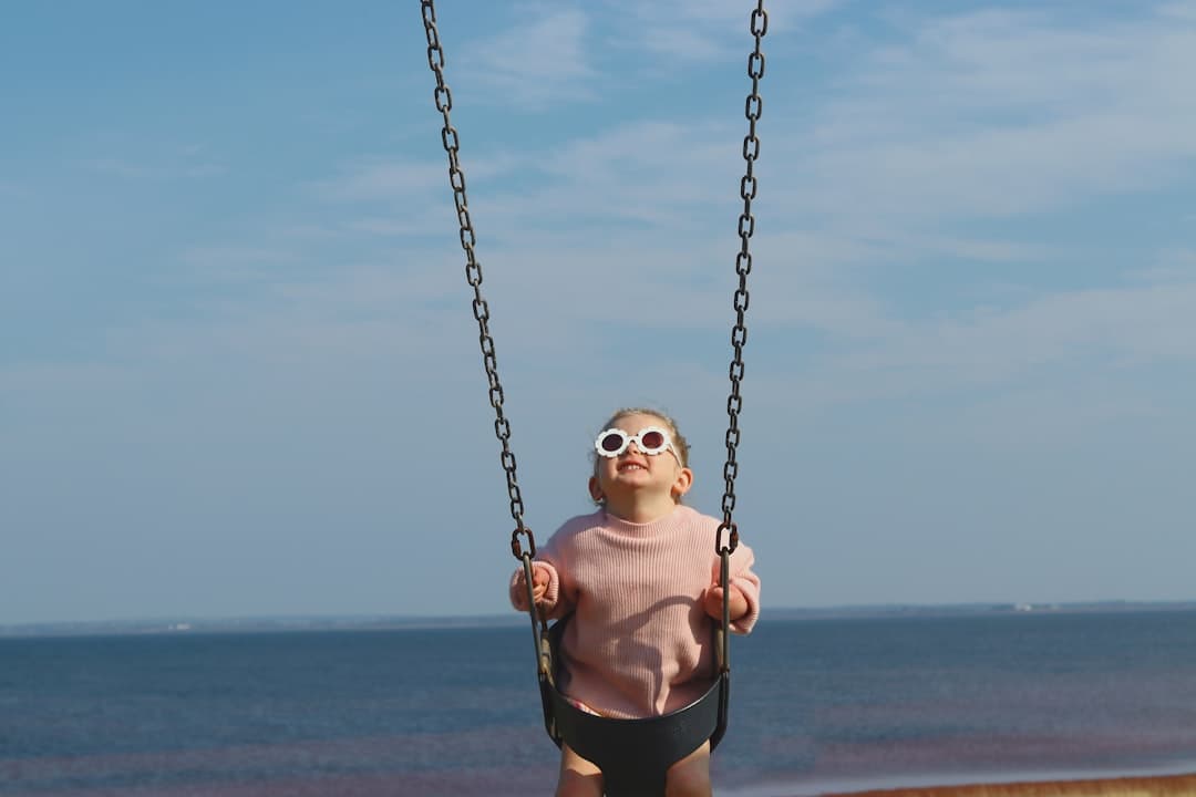 A woman in a pink shirt swinging on a swing