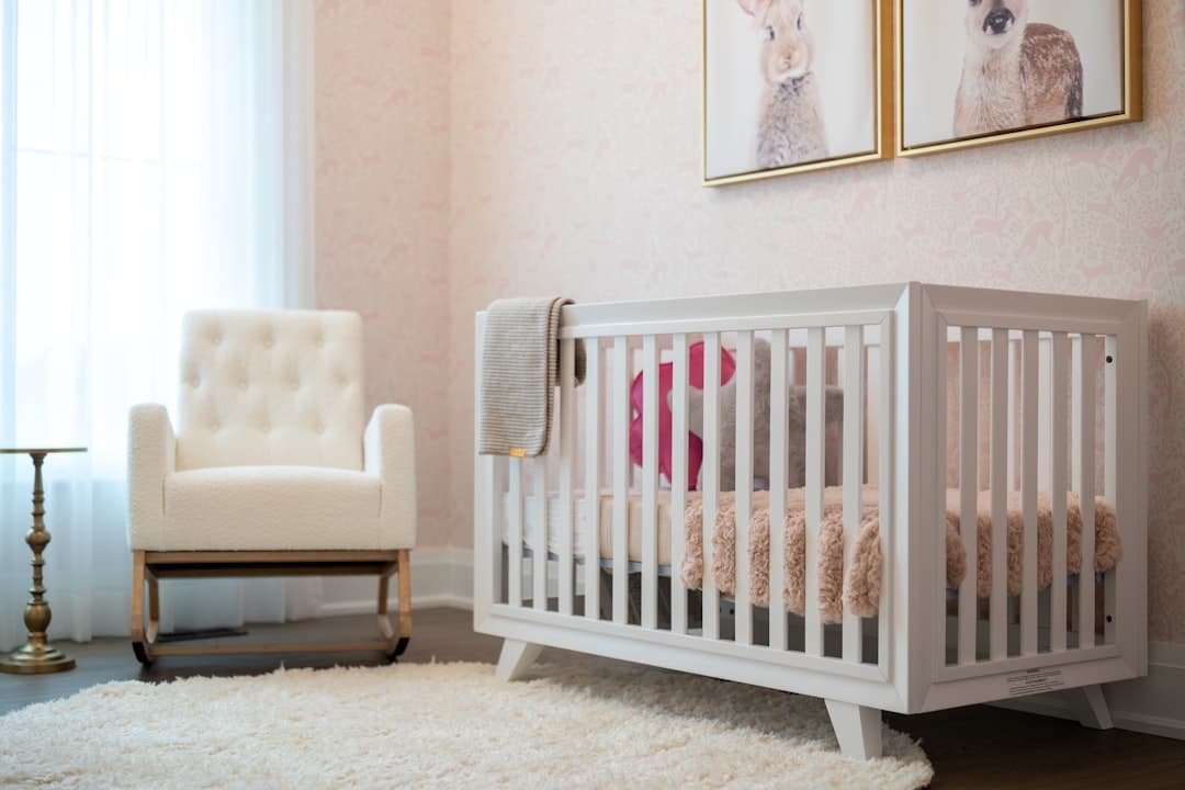 A cozy nursery with a white crib and armchair.