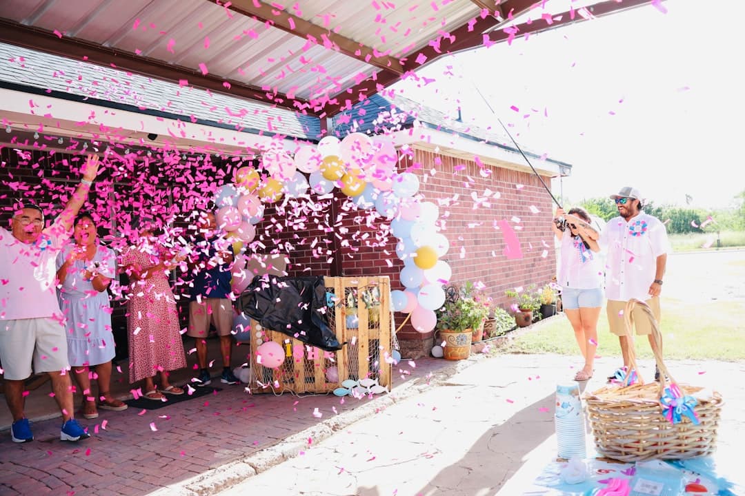 People celebrating with pink confetti and balloons