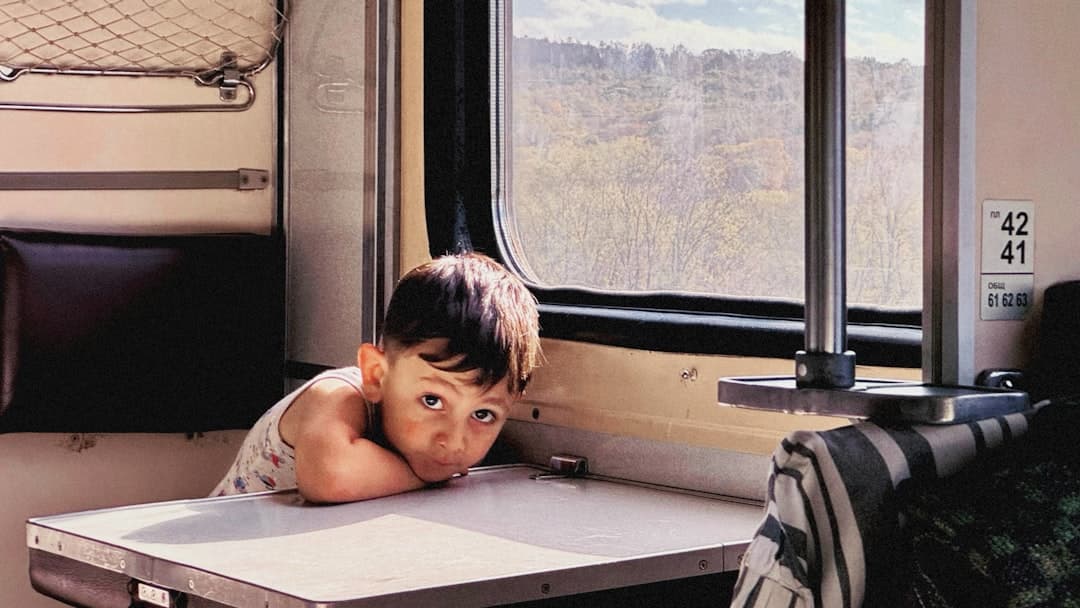 A small child sitting on a table in front of a window